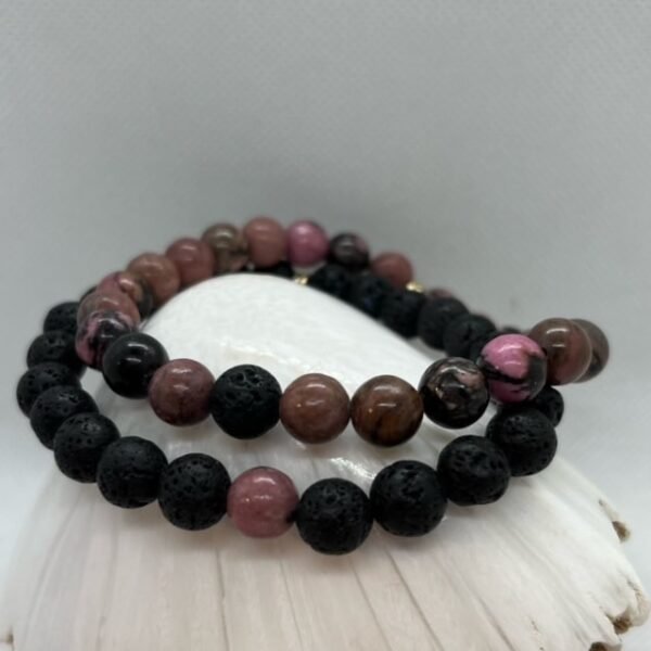 Bracelets duo en Rhodonite et Pierre de Lave. La Pierre de Lave va atténuer le stress, l'anxiété, favoriser un sentiment de sécurité et d'enracinement. La rhodonite associé au chakra du cœur, vous aide à guérir des blessures affectives comme les séparations, divorce ou deuil.